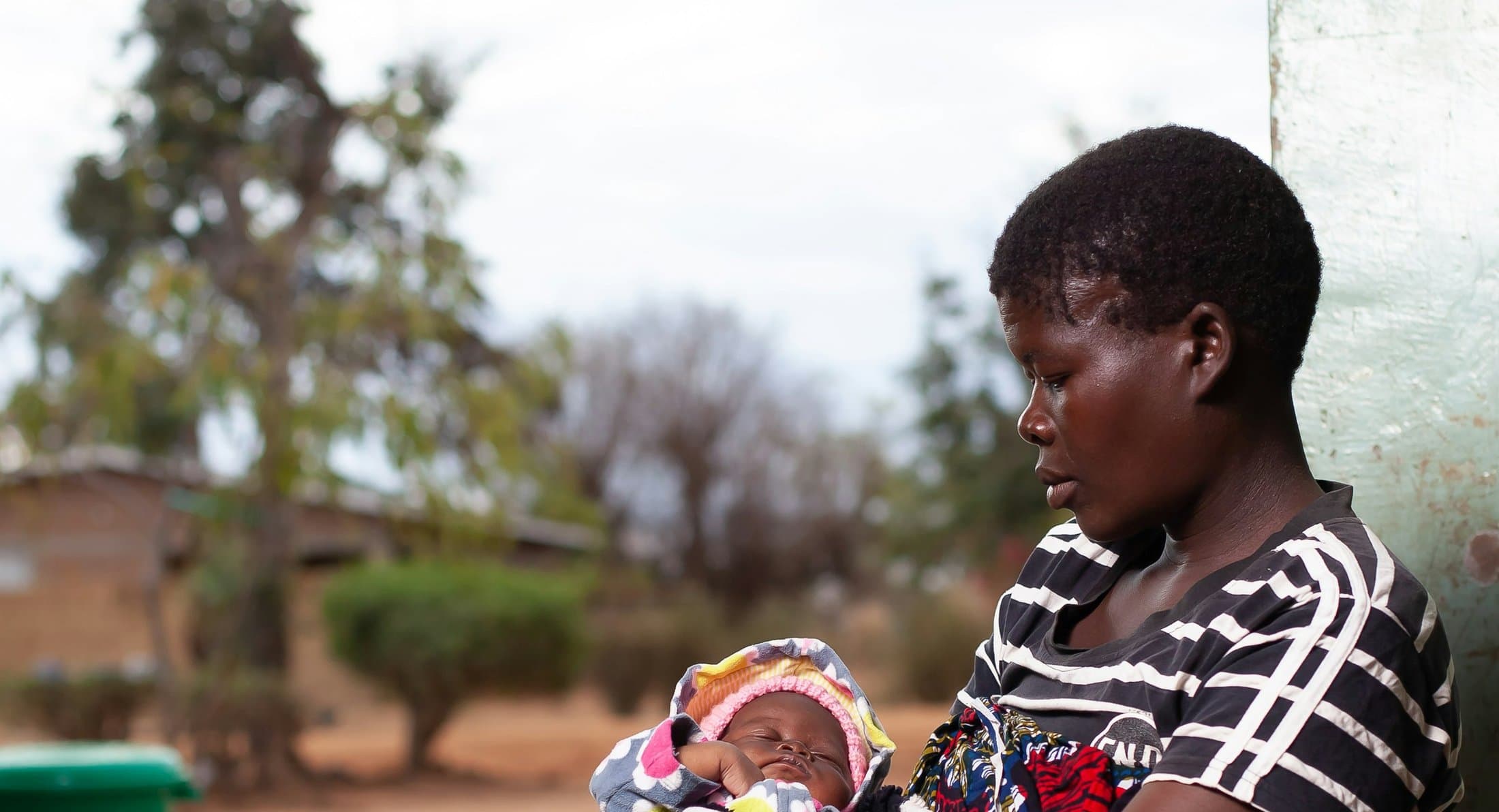 A mother tenderly holding her newborn baby, representing the families the sponsorship fund supports